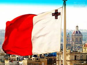 Proud to be Maltese! The flag of Malta flaps in the wind with the historic city of Senglea in the background rita attard